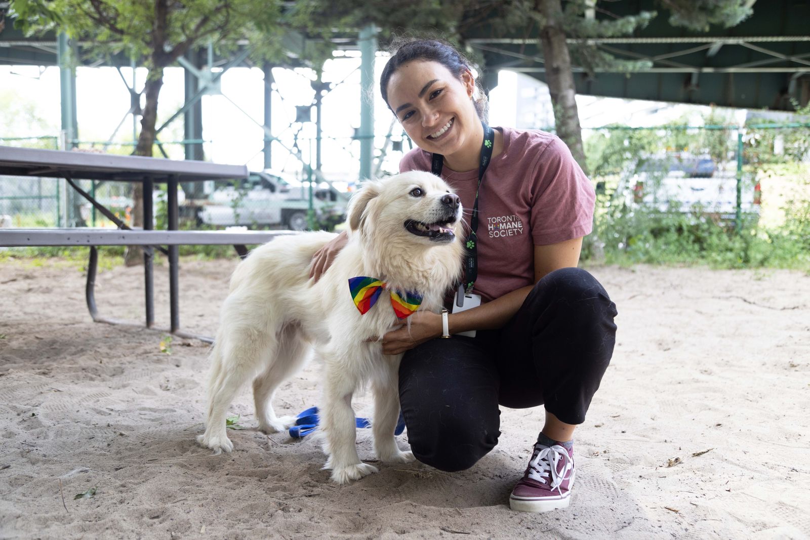 Young woman with brunette hair holding a white fluffy dog